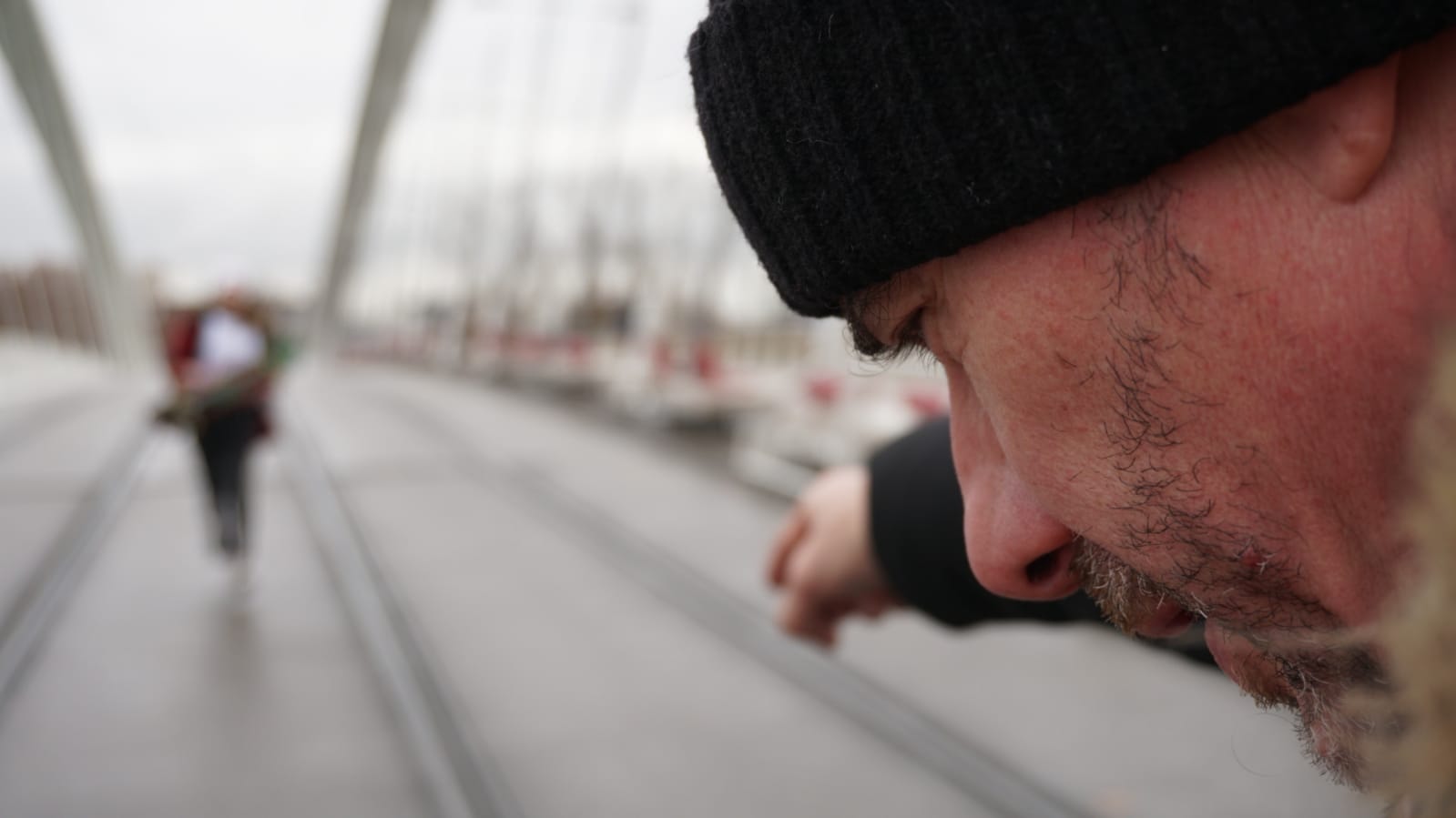 Tournage vidéo d'entreprise Carestream Dental : homme au bonnet observant les rails sur un pont