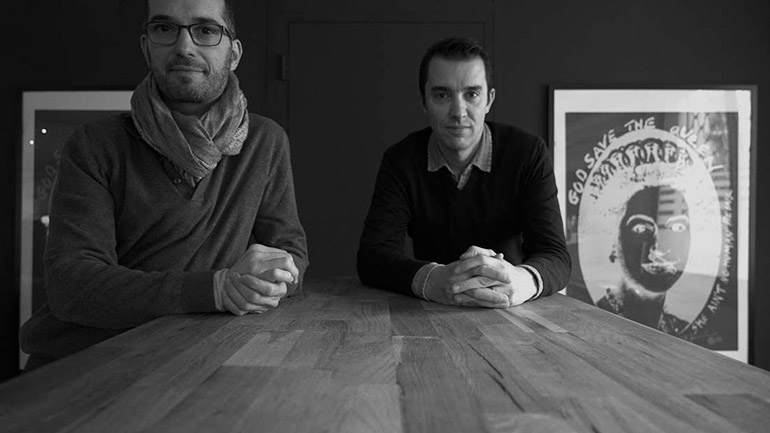 Agence de film d'entreprise à Lyon : les deux fondateurs d'EO Be Creative assis côte à côte en noir et blanc