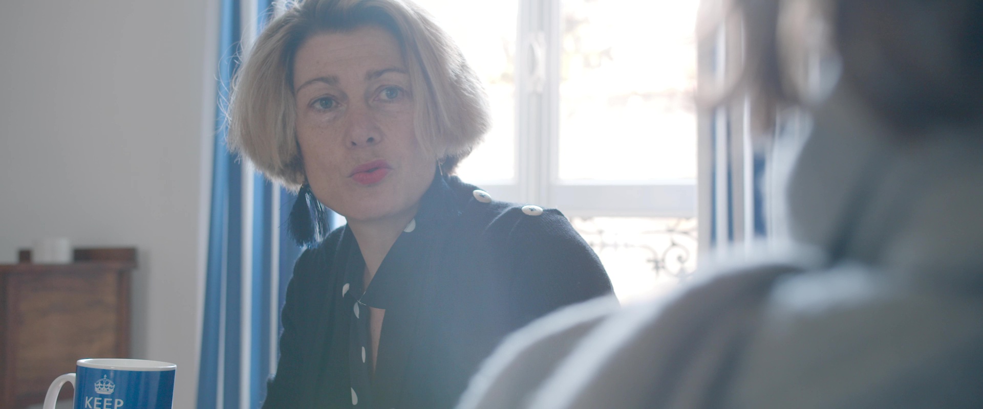 Film d'entreprise Sigvaris : femme en discussion près d'une fenêtre, lumière naturelle et ambiance chaleureuse