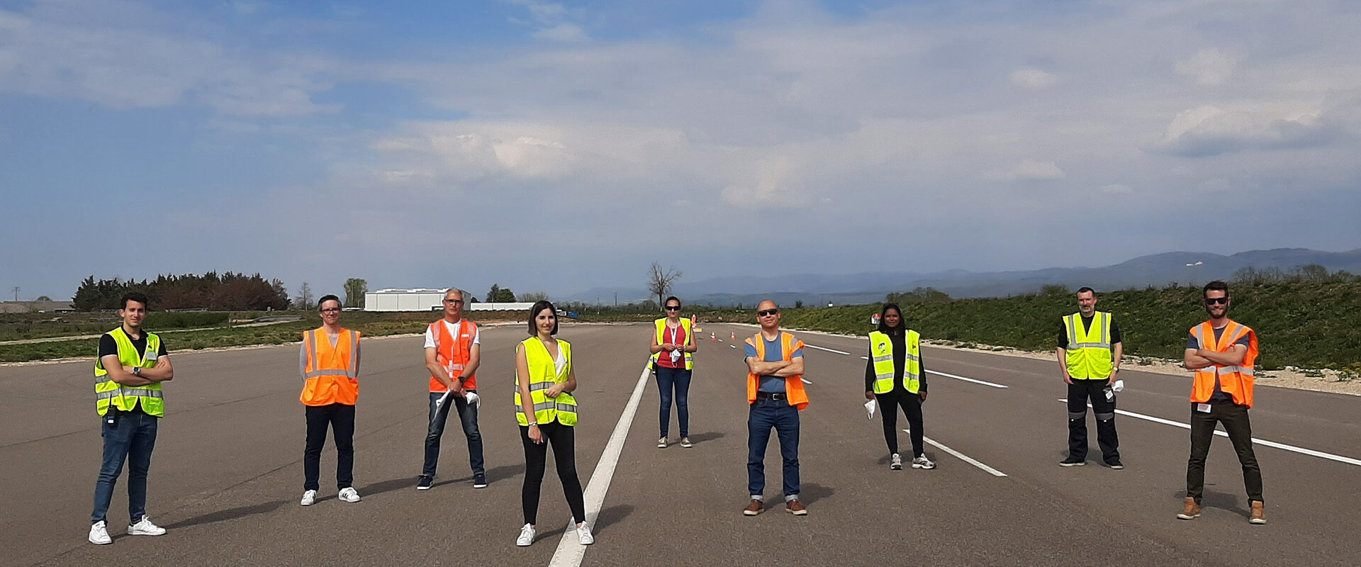 Tournage vidéo d'entreprise pour APRR : équipe en gilets fluo alignée sur piste d'essai Transpolis
