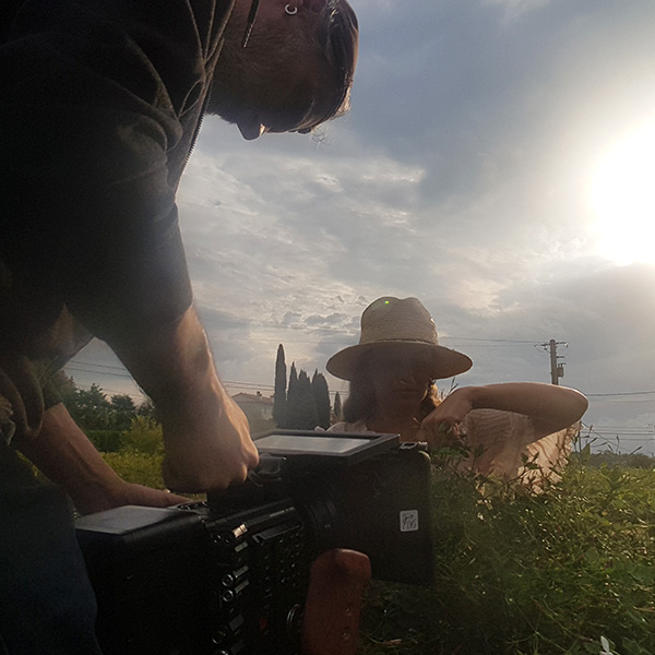 Tournage du film de marque Mane Group : cadreur filme une comédienne en extérieur au coucher du soleil