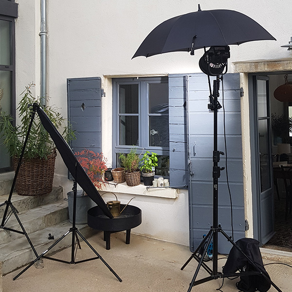 Tournage vidéo d'entreprise Mane Group : éclairage et parapluie photo installés dans une cour extérieure