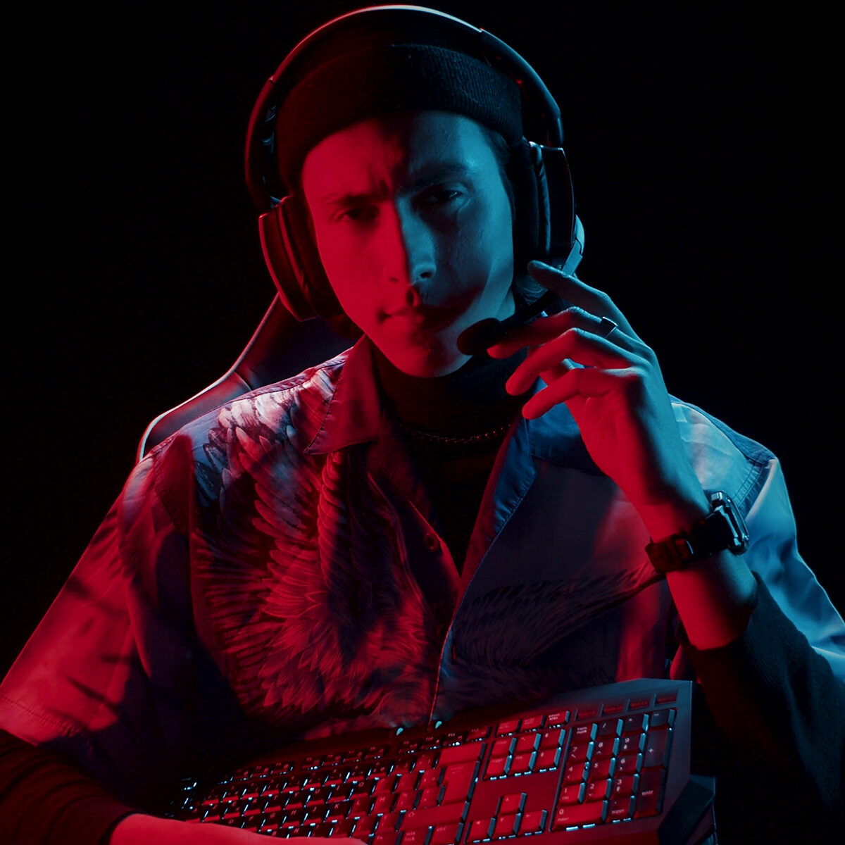 Spot publicitaire gaming pour MYM : gamer au casque ajustant son micro sous éclairage rouge et bleu