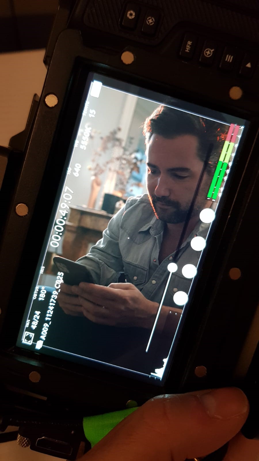 Tournage vidéo d'entreprise pour MYM : moniteur de caméra affichant un homme consultant son smartphone