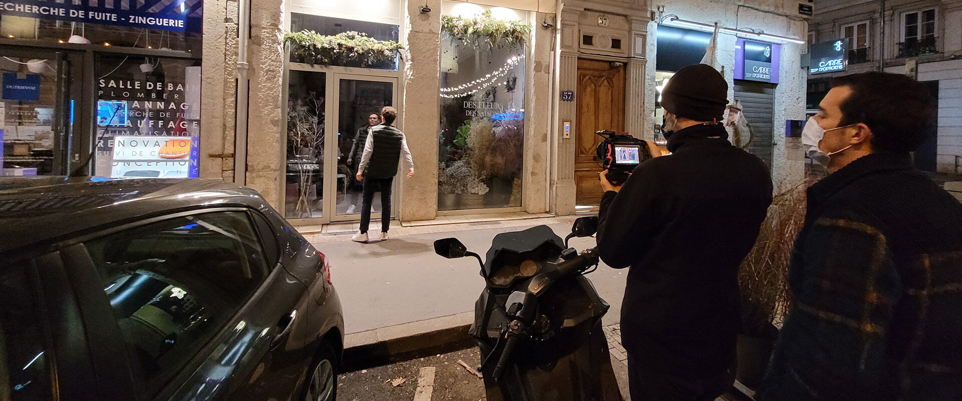 Tournage vidéo d'entreprise Nexans : caméraman filmant une scène de nuit devant un fleuriste