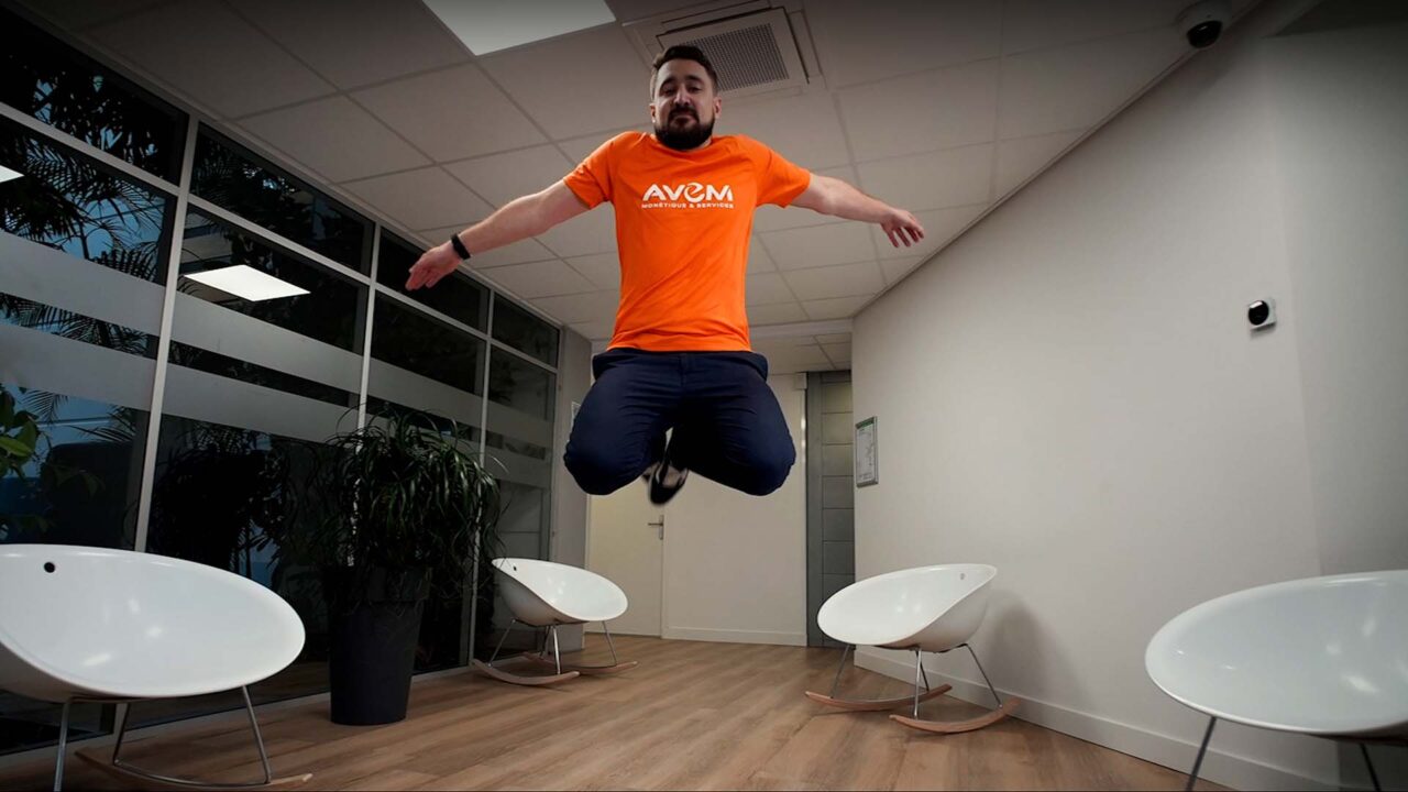 Collaborateur AVEM en t-shirt orange en suspension stop motion, film événementiel vœux 2023, finance et assurance