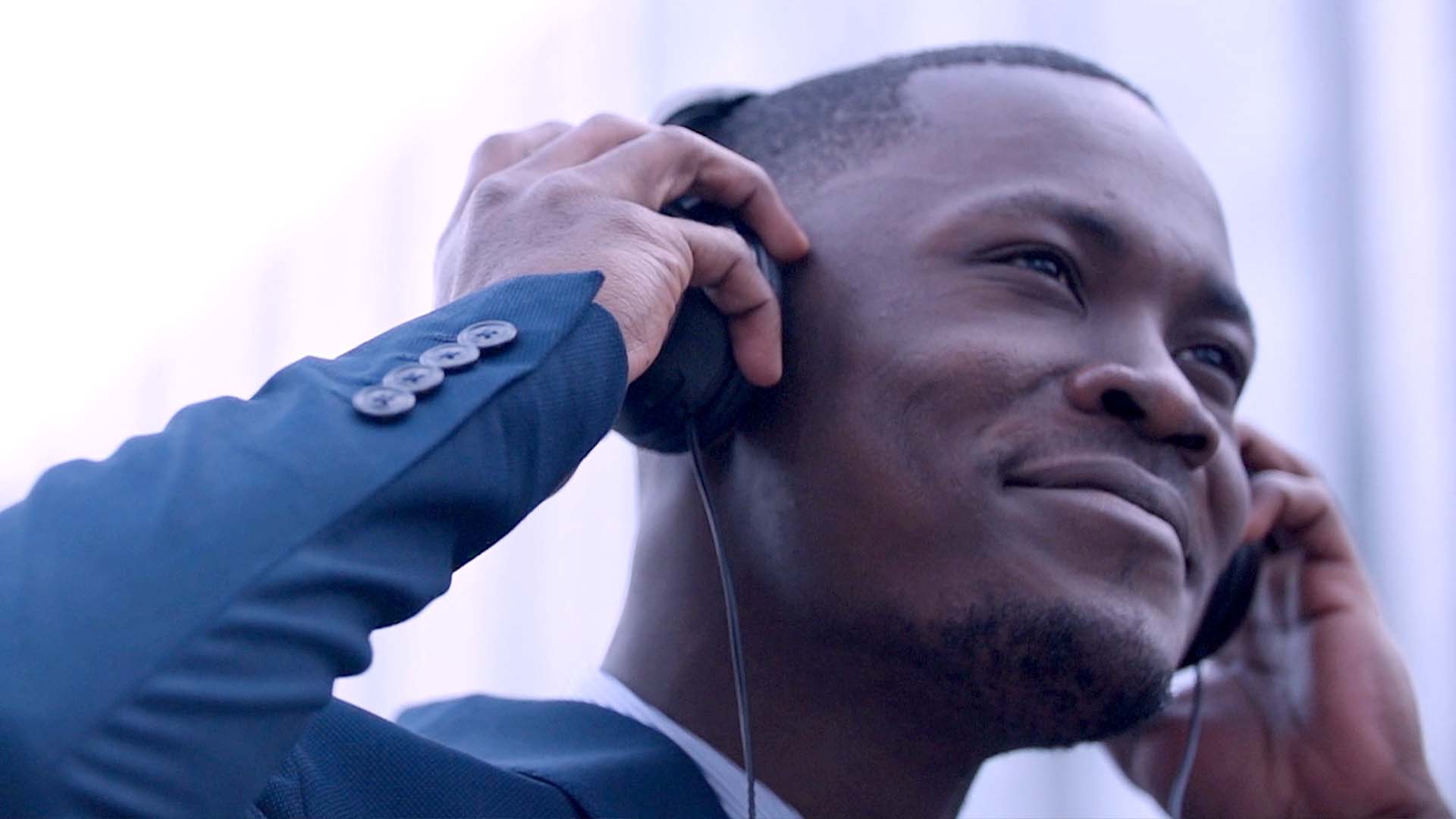 Cadre en costume ajustant un casque audio, campagne vidéo du groupe financier BGFI Bank