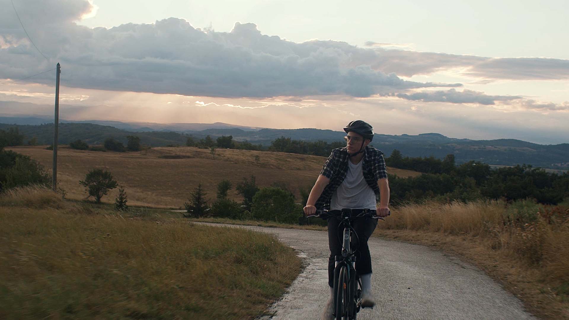 Cycliste casqué sur route de campagne au crépuscule, film d'onboarding pour Brioche Pasquier, boulangerie industrielle