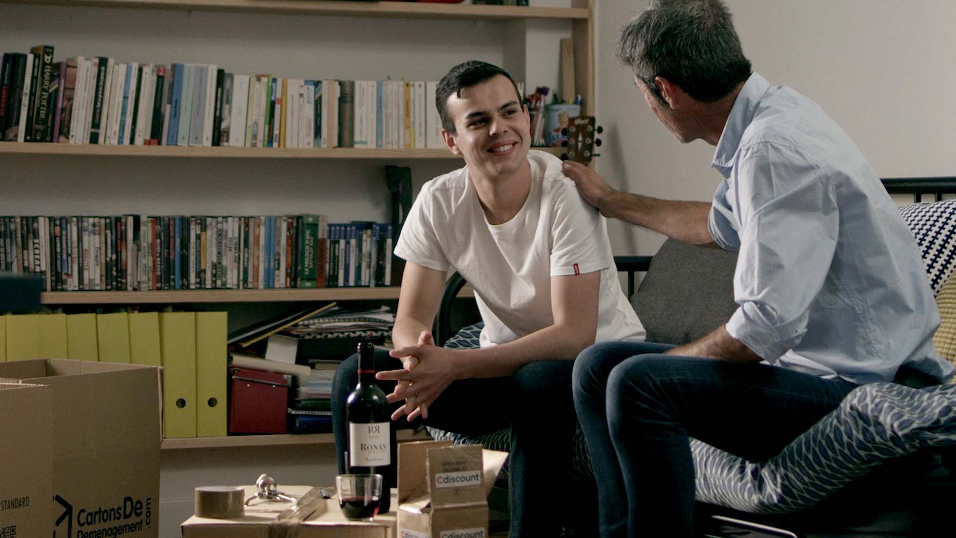 Jeune homme et homme plus âgé complices dans un appartement avec cartons Cdiscount, film de marque pour ce leader du e-commerce