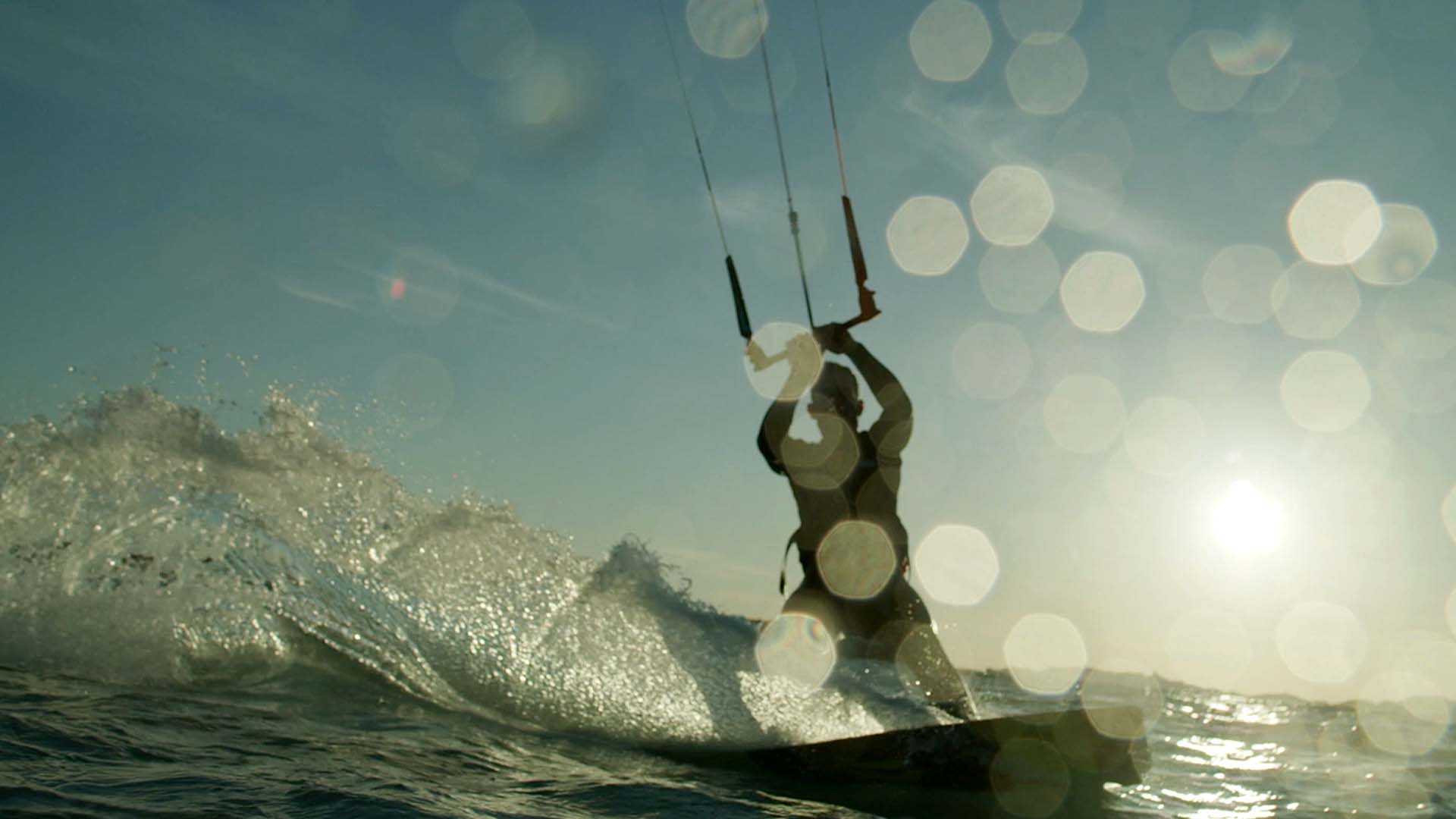 Kitesurfeur en silhouette sur une vague au soleil, film d'entreprise Everial, groupe de services