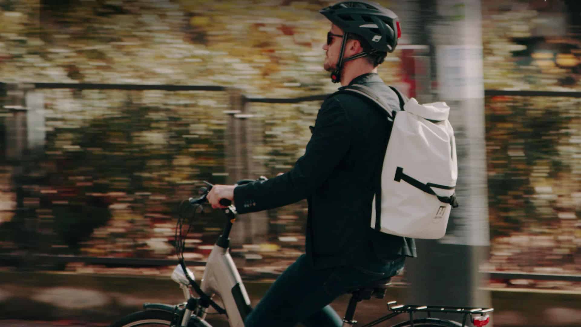 Cycliste casqué sur vélo électrique en ville, spot TV pour Feu Vert E-Roll 72, enseigne de distribution