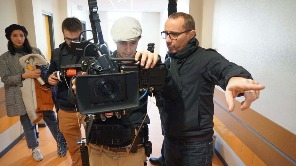 Réalisateur guidant le chef opérateur caméra à l’épaule, tournage vidéo EO Be Creative en entreprise