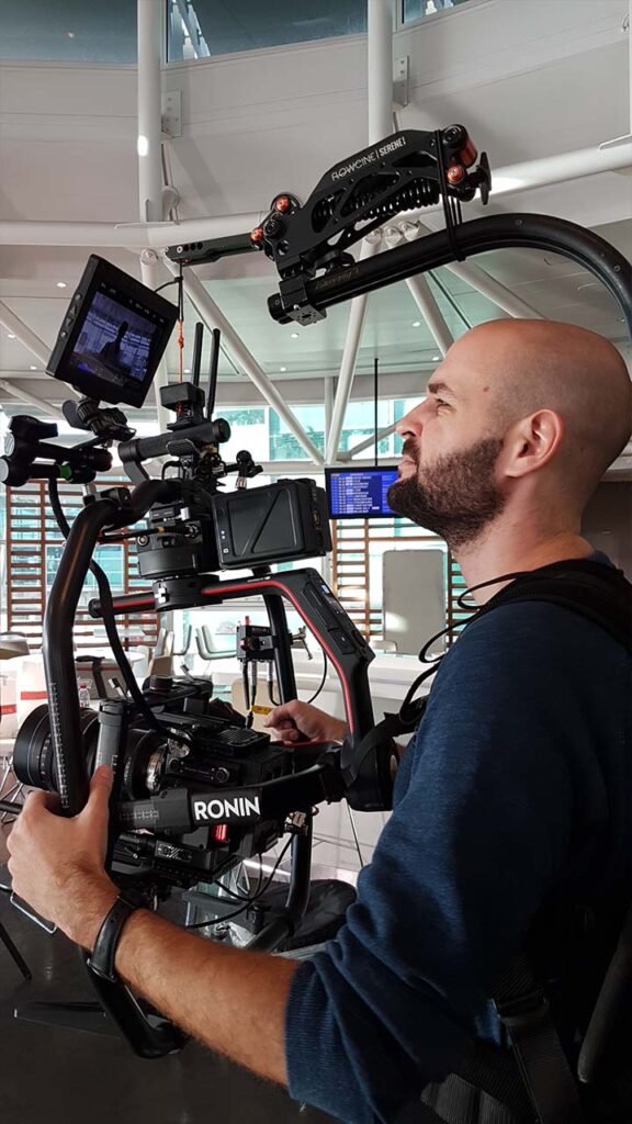 Chef opérateur EO Be Creative réglant une caméra cinéma sur son rig, prise de vues en salle de sport