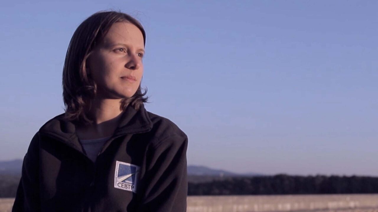 Collaboratrice Ginger CEBTP en veste de terrain, regard vers l'horizon, film publicitaire sur l'ingénierie des sols