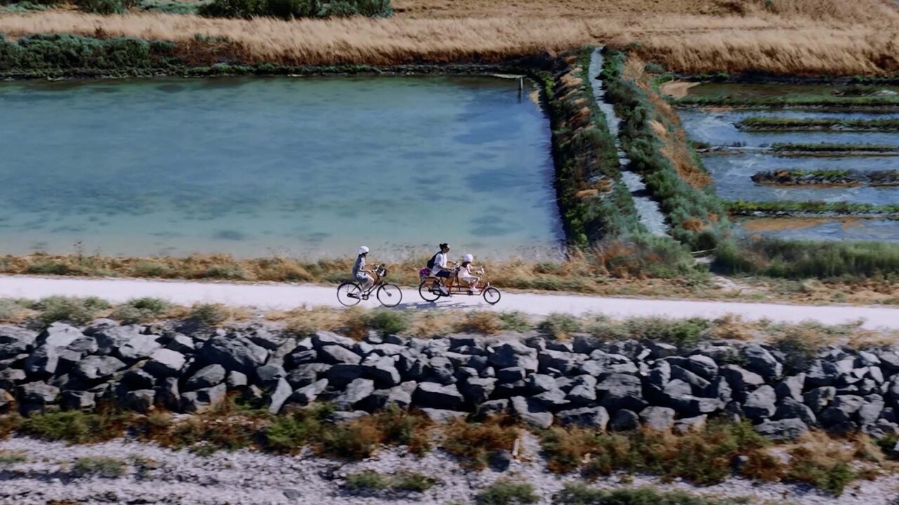 Famille pédalant sur un tandem le long des marais de l'Île de Ré, film publicitaire Holland Bikes