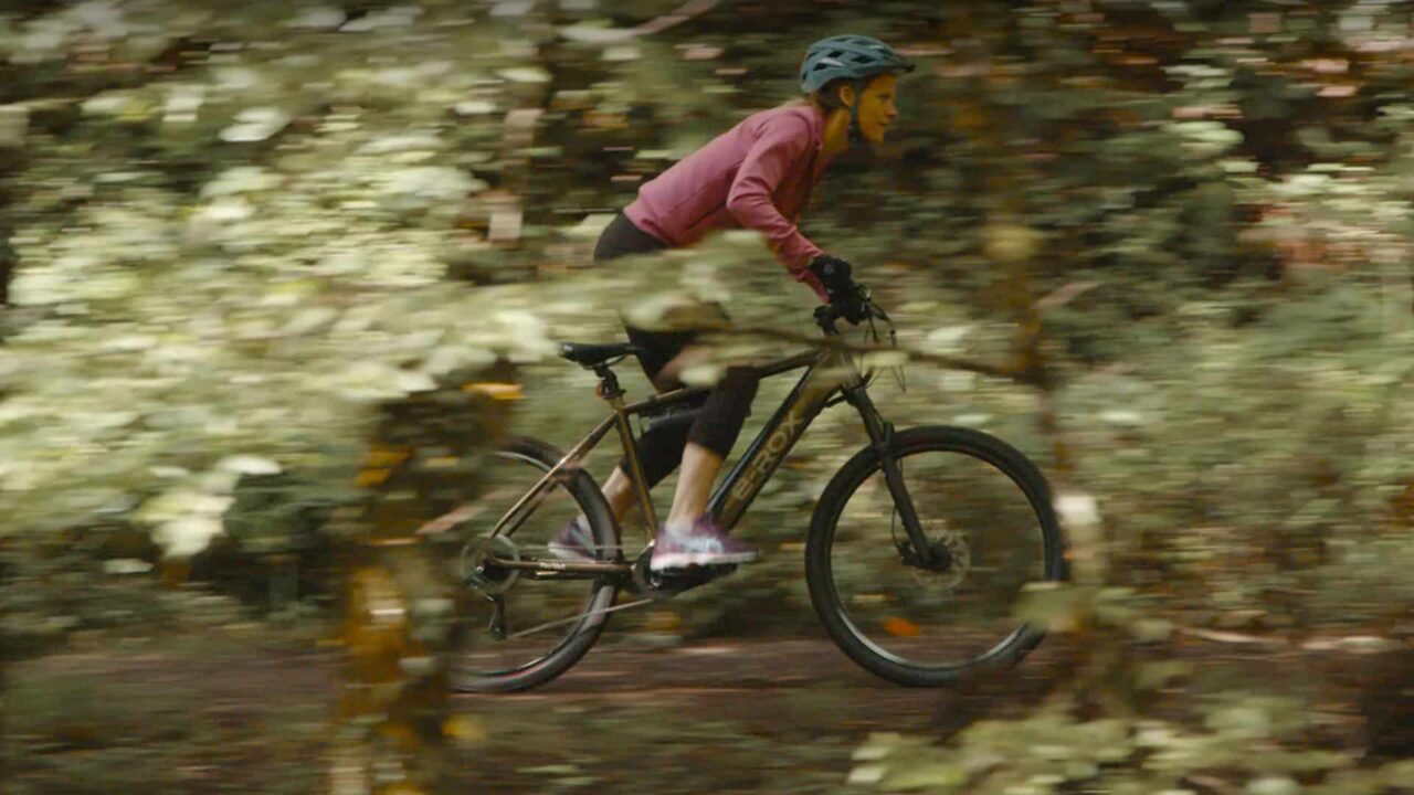 Cycliste sur vélo électrique E-Rox Feu Vert en forêt, enseigne de distribution, film publicitaire