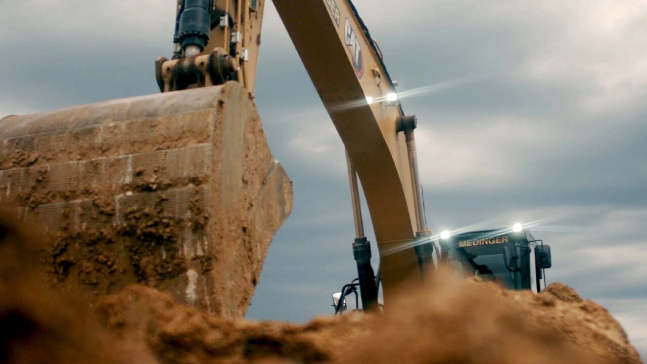 Pelleteuse Medinger chargée de terre sur chantier, film d'entreprise travaux publics Île-de-France
