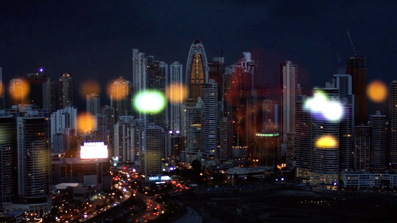 Skyline nocturne aux reflets colorés illustrant la dimension internationale de NGE, groupe BTP, dans son film de marque