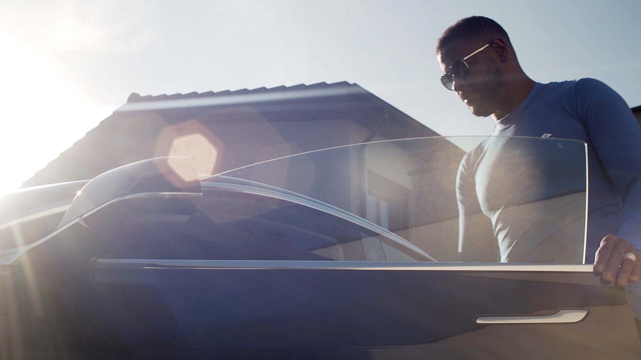 Homme ouvrant une portière de berline en plein soleil, film institutionnel Optimum Automotive, gestion de flottes automobiles