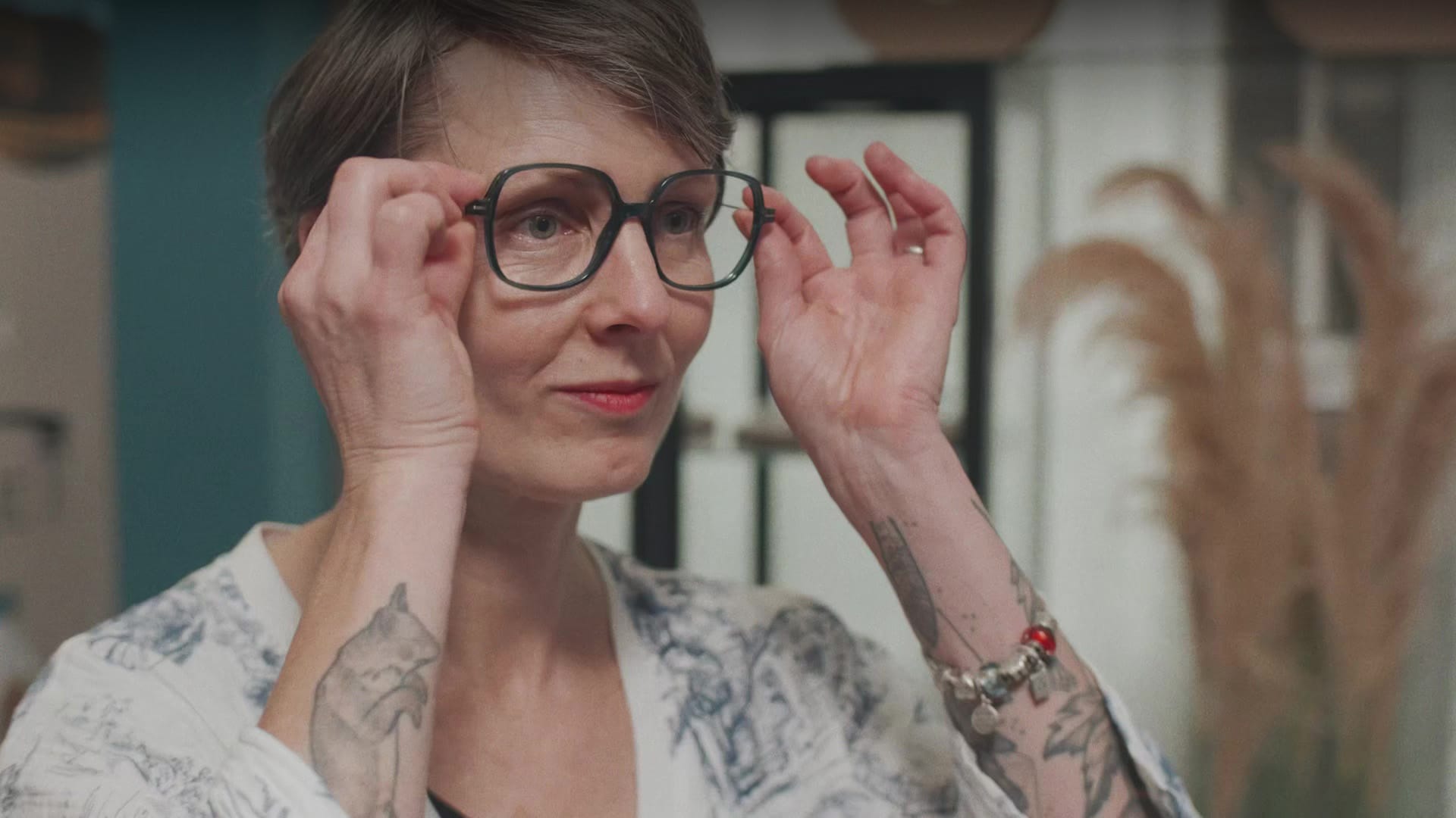 Femme tatouée ajustant ses lunettes Nocle, film d'entreprise Santéclair sur l'optique française
