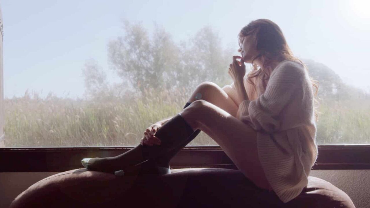 Femme sereine face à une fenêtre brumeuse — film de présentation Sigvaris, compression médicale