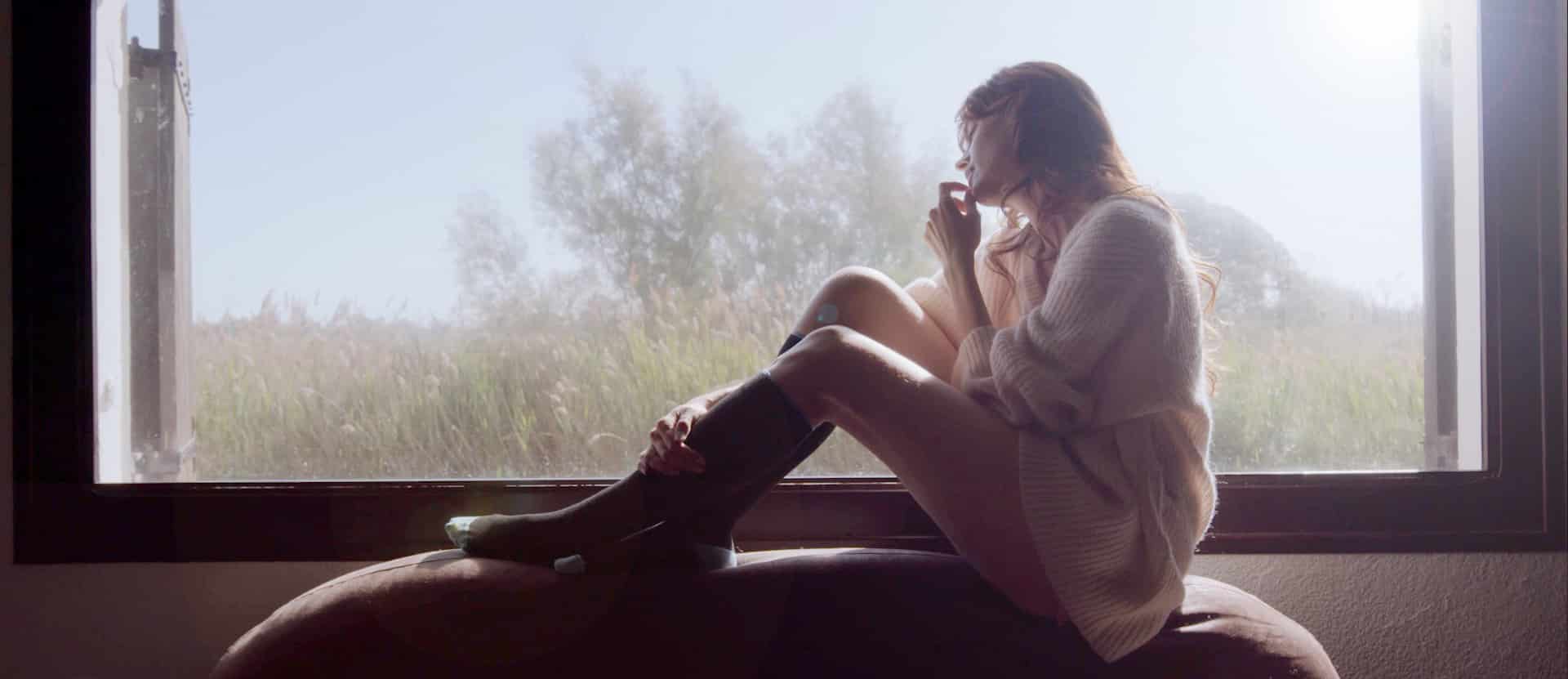 Femme sereine face à une fenêtre brumeuse — film de présentation Sigvaris, compression médicale