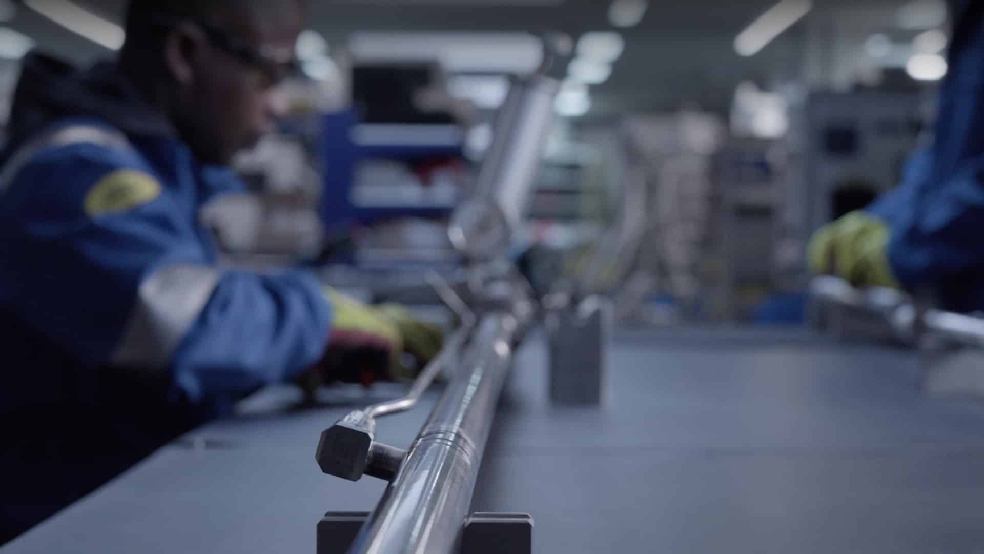 Technicien assemblant une pièce métallique en atelier, film de présentation de SLB, acteur de l'énergie