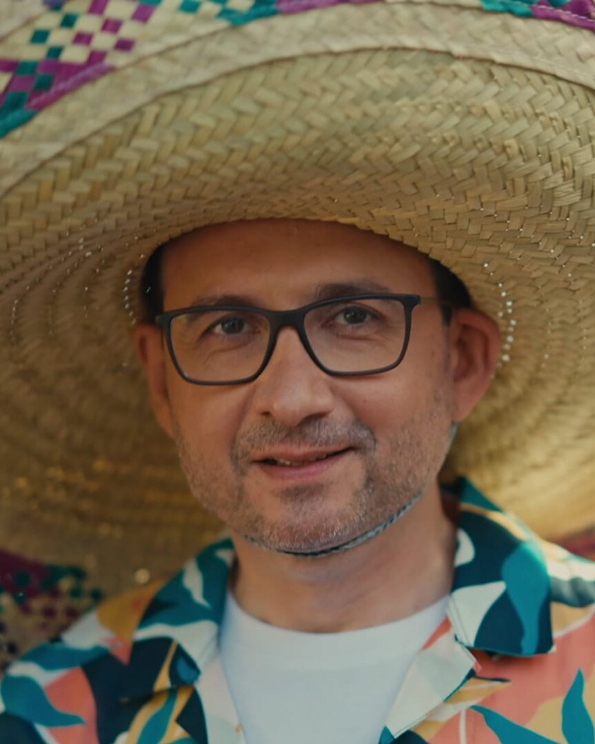 Homme souriant en sombrero coloré, ambiance feel good pour la campagne vidéo Avatacar, réseau de garages