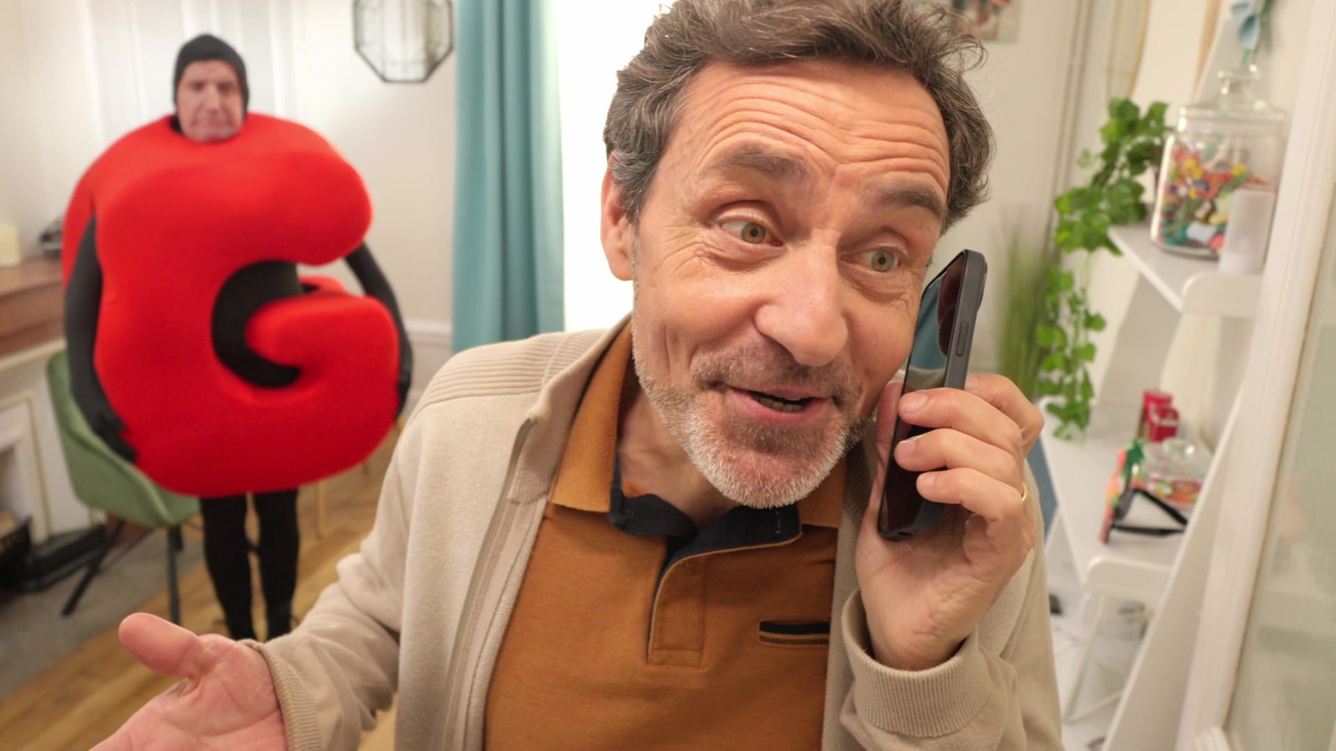 Comédien au téléphone face à un personnage en costume G rouge, campagne vidéo Bail Rénov' rénovation énergétique