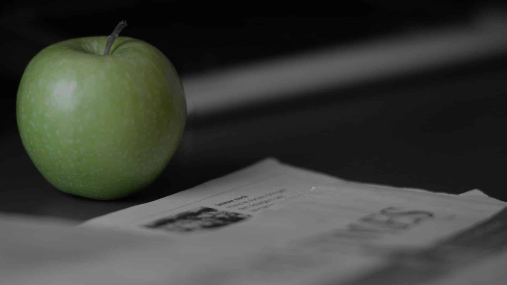 Pomme verte et journal en noir et blanc pour la vidéo institutionnelle de Carmignac, gestionnaire d'actifs