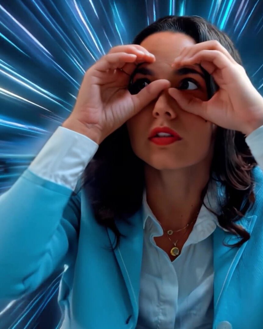 Comédienne mimant des jumelles sur fond lumineux bleu, campagne vidéo Econocom pour sa solution IT i.tem