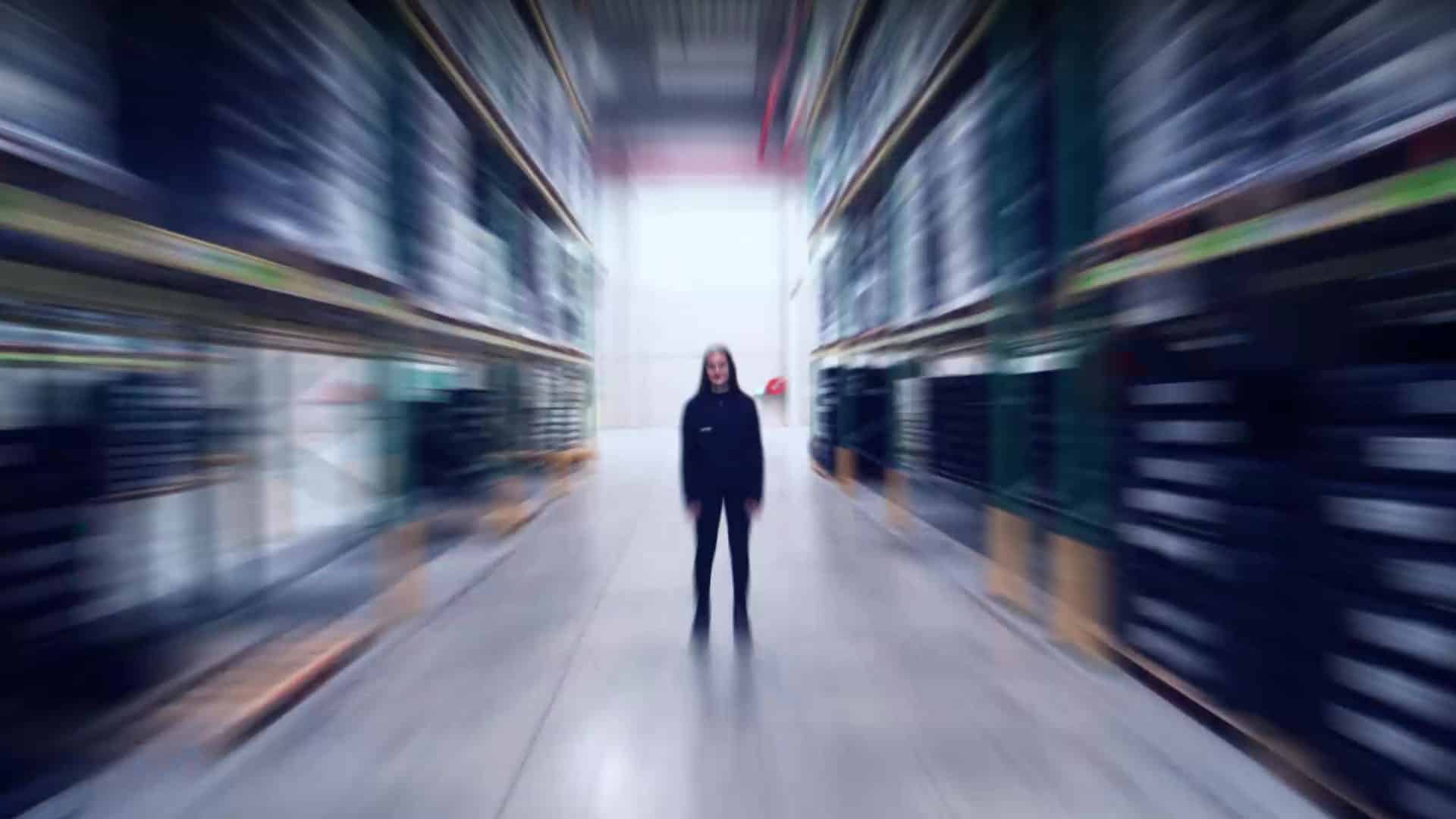 Collaboratrice dans une allée d'entrepôt Feu Vert, enseigne de distribution, film événementiel