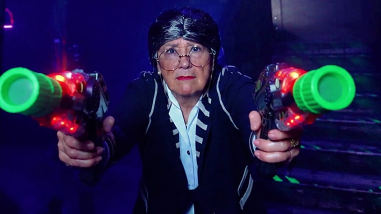 Spot publicitaire Megazone : femme armée de deux pistolets laser dans une arène fluo