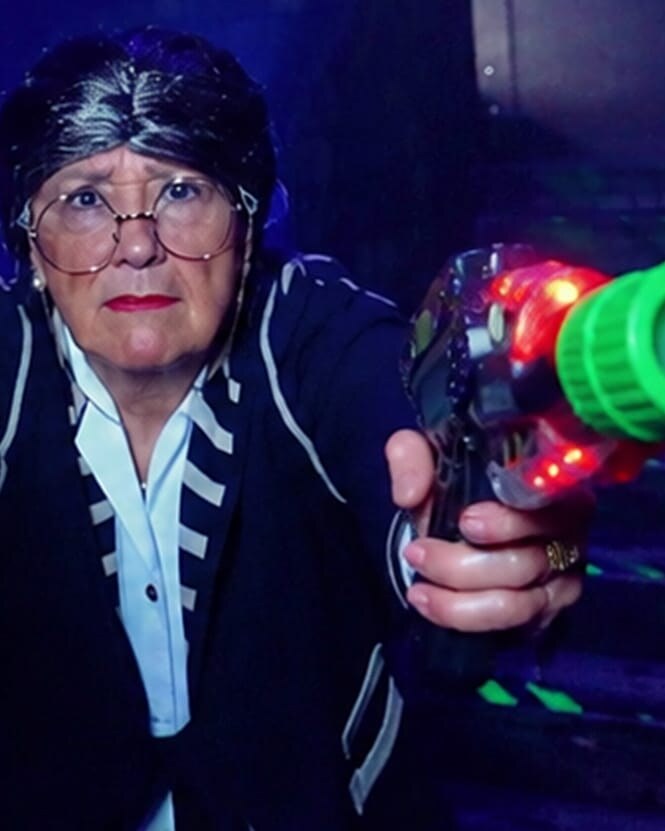 Spot publicitaire Megazone : femme armée de deux pistolets laser dans une arène fluo
