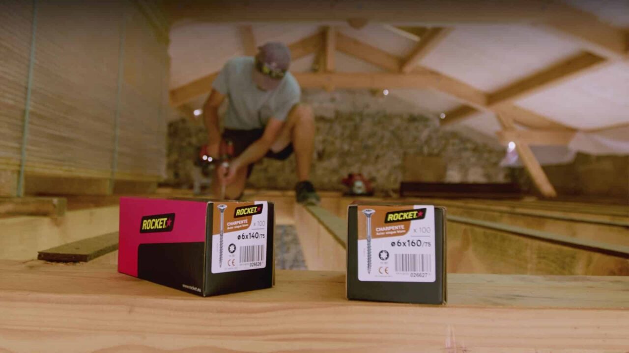 Boîtes de vis Rocket charpente au premier plan, artisan posant un plancher — film d'entreprise Rocket