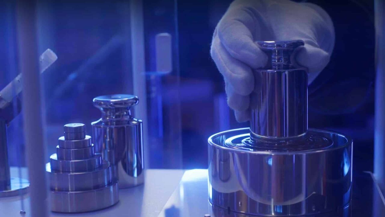 Main gantée posant un étalon sur balance de précision, vidéo corporate Trescal étalonnage industriel